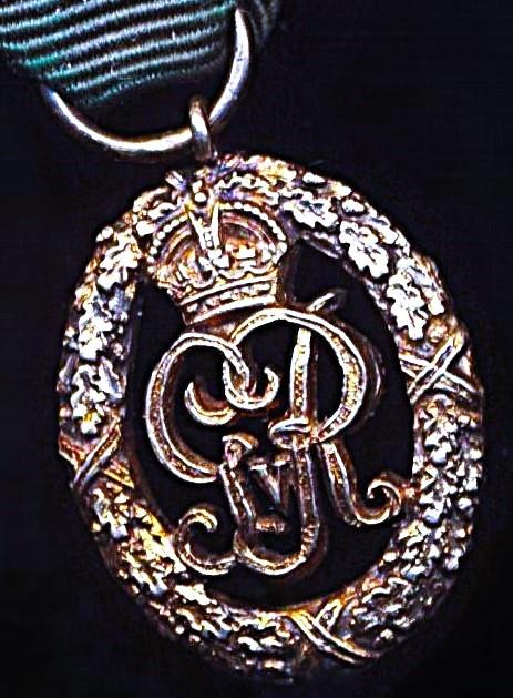 United Kingdom: Volunteer Decoration. With GV obverse cypher and the riband complete with the integral silver top brooch bar (with pin & clasp fittings).