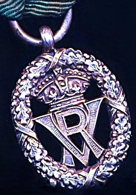 United Kingdom: Volunteer Decoration. With VR obverse cypher and the riband complete with the integral silver top brooch bar (with pin & clasp fittings)