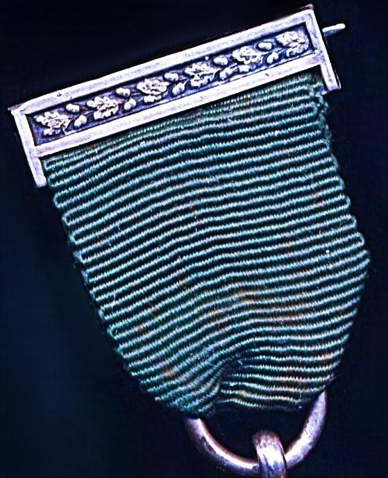 United Kingdom: Volunteer Decoration. With VR obverse cypher and the riband complete with the integral silver top brooch bar (with pin & clasp fittings)